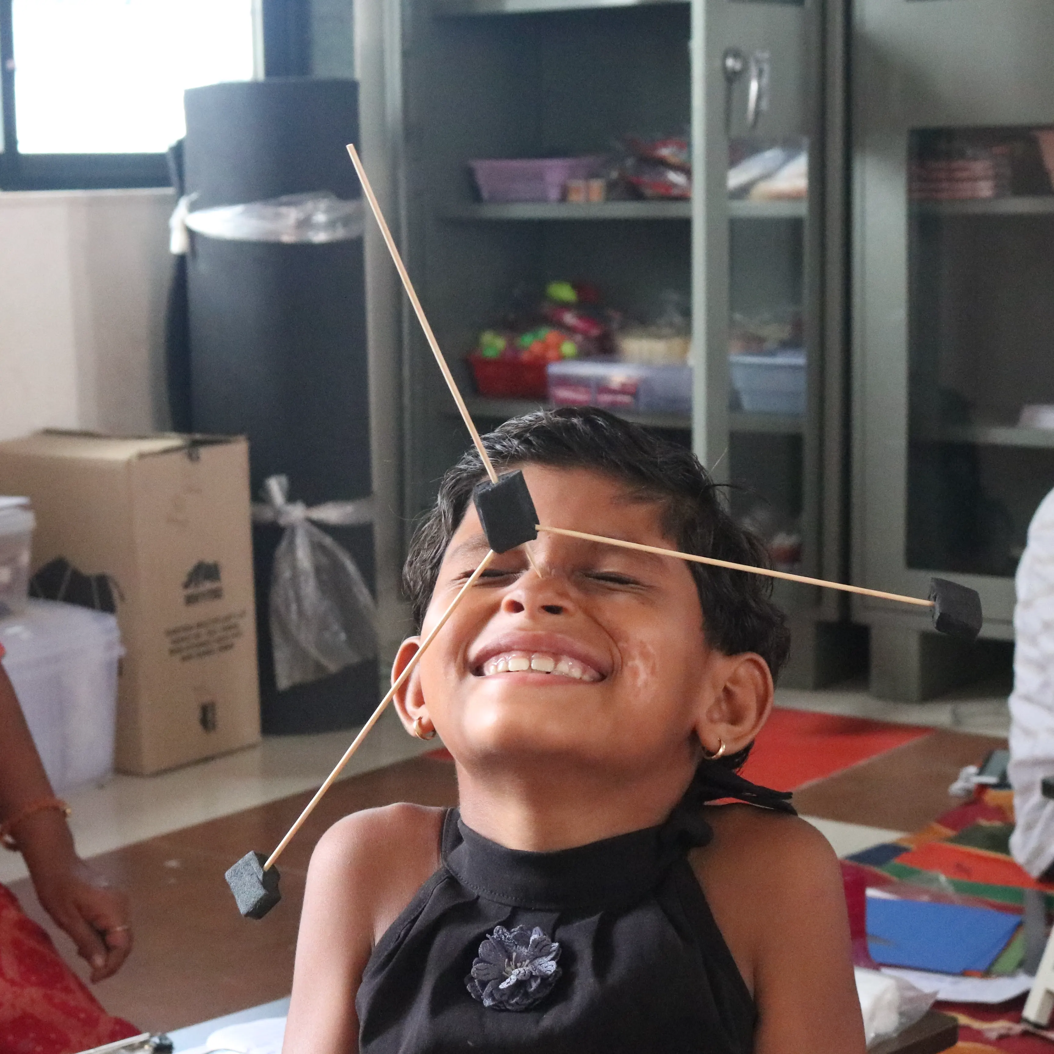 A toy neatly balanced on a student's nose